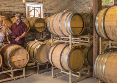 Bryan Ulbrich taking wine from a barrel in The Barrel Room